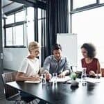 Three Internship Coaches Sitting At Table Discussing Client Job Applications